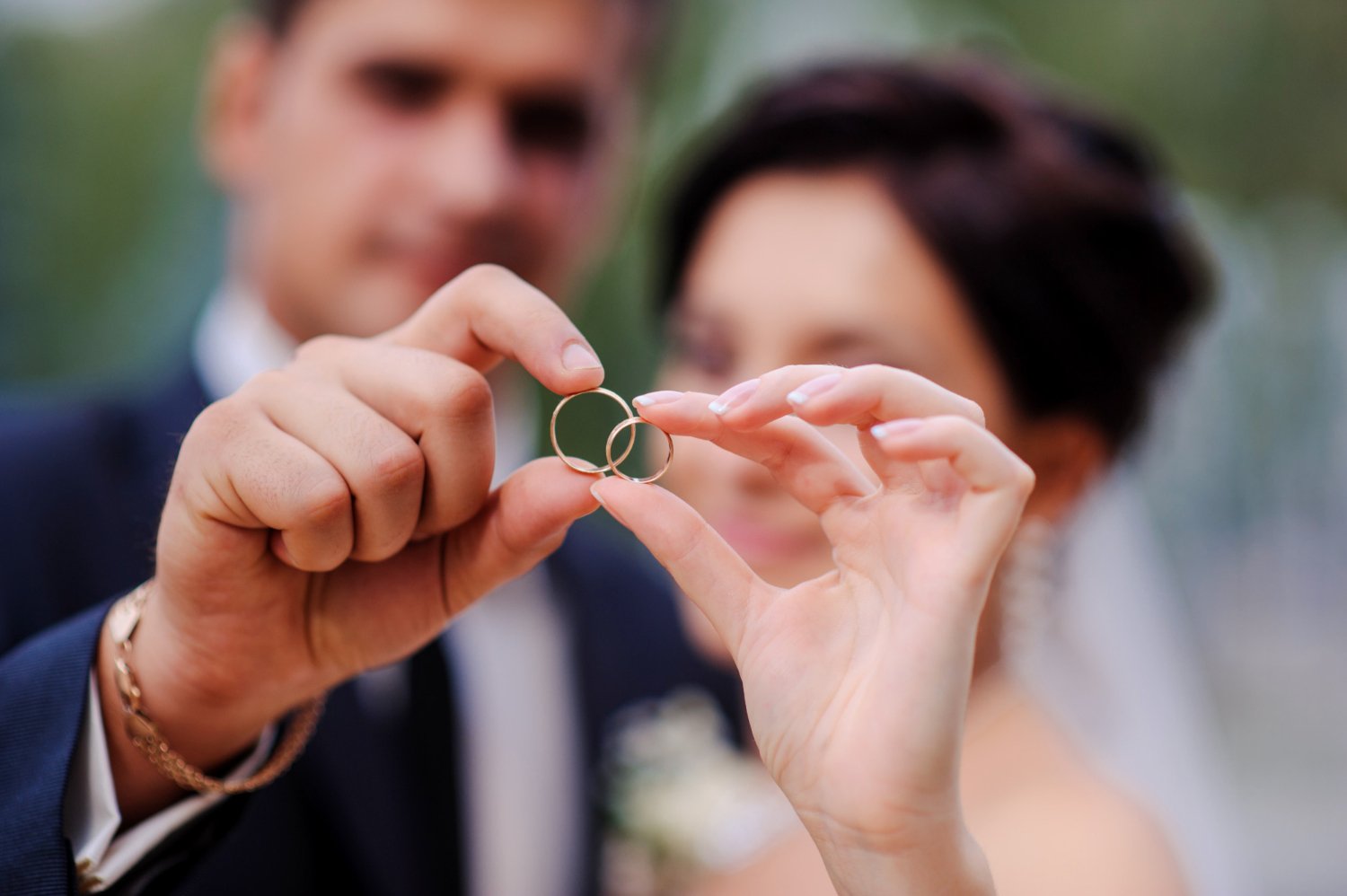 bride and groom holding hands in a ring